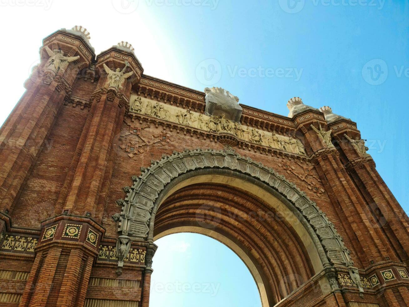 The Arc de Triomf in Barcelona on a sunny day with some tourists photo
