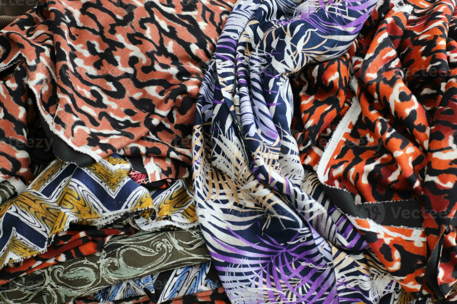Detailed close up view on samples of cloth and fabrics in different colors found at a fabrics market photo