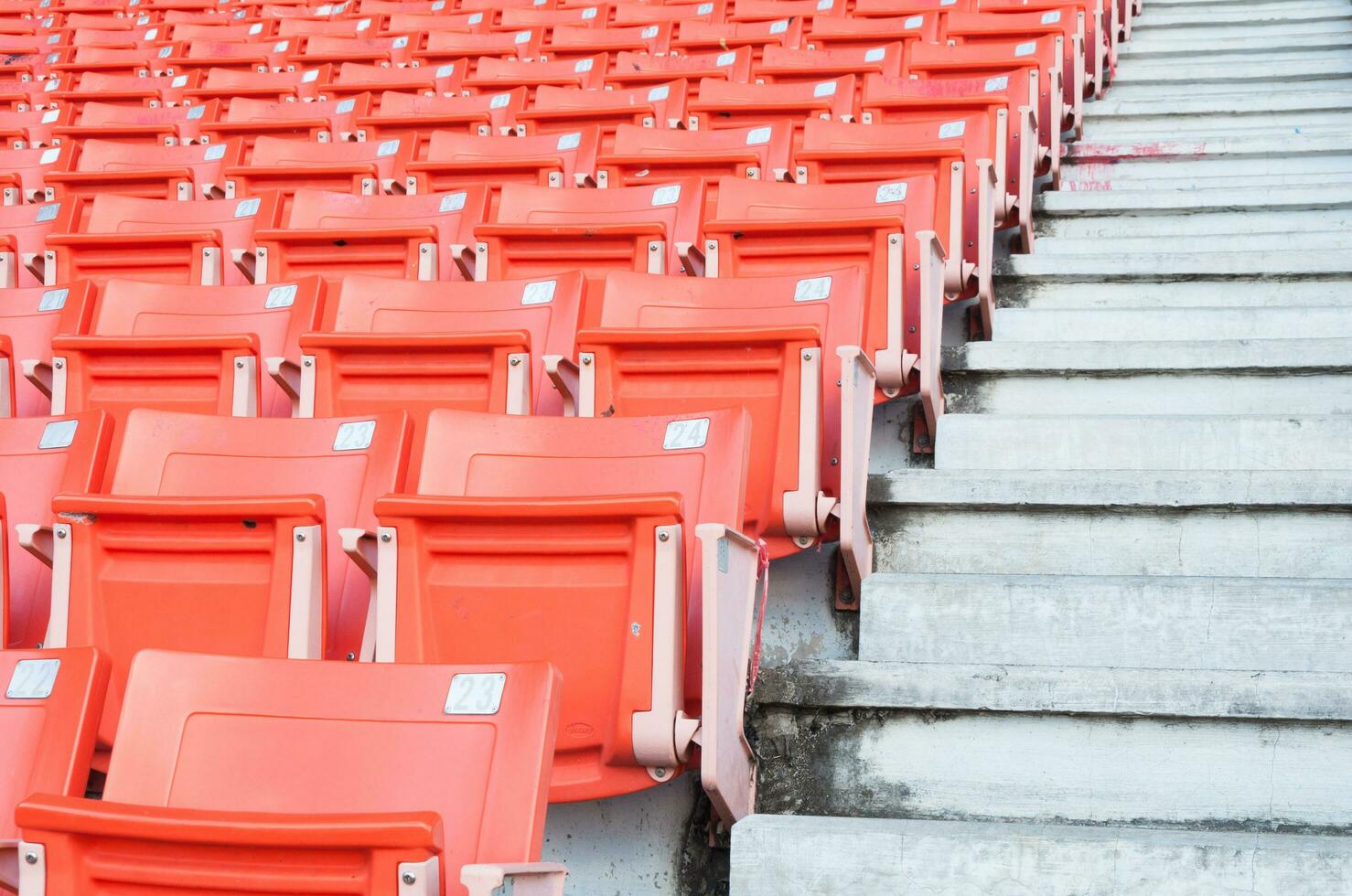Empty orange seats at stadium,Rows of seat on a soccer stadium photo