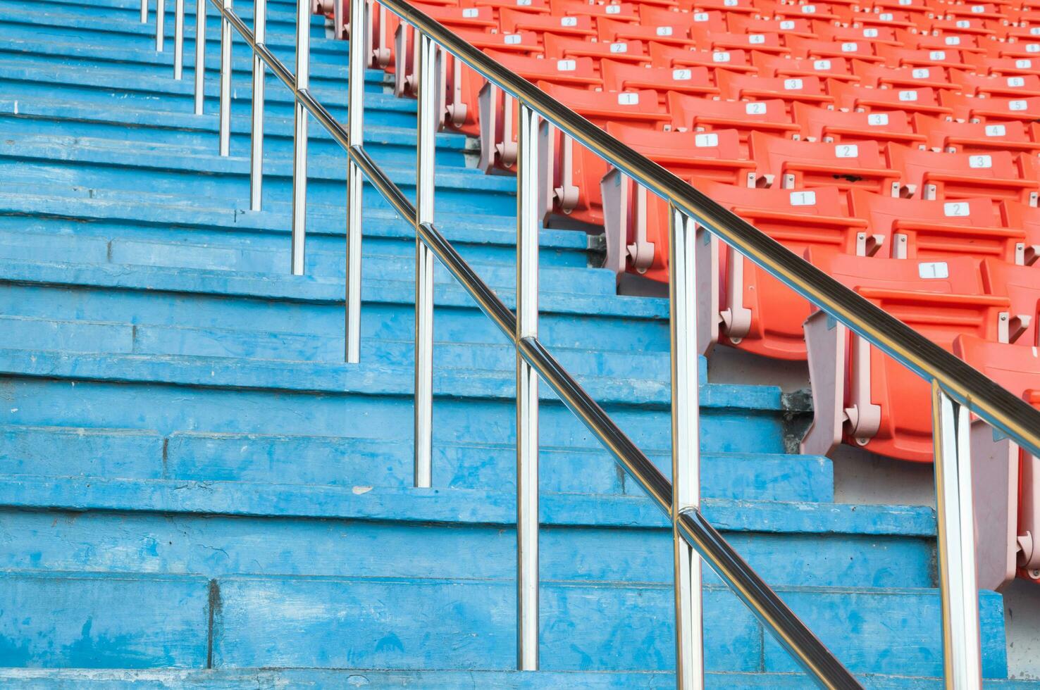 Empty orange seats at stadium,Rows walkway of seat on a soccer stadium photo