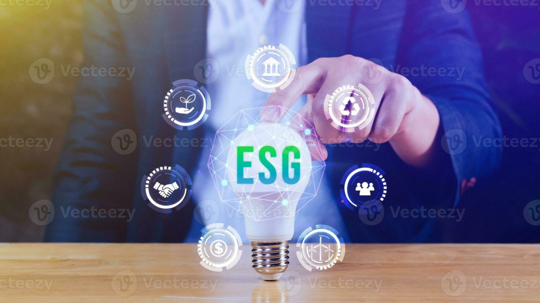 Businessman hand holding light bulb with ESG icon concept for environmental, social, and governance in sustainable and ethical business on the Network connection. photo