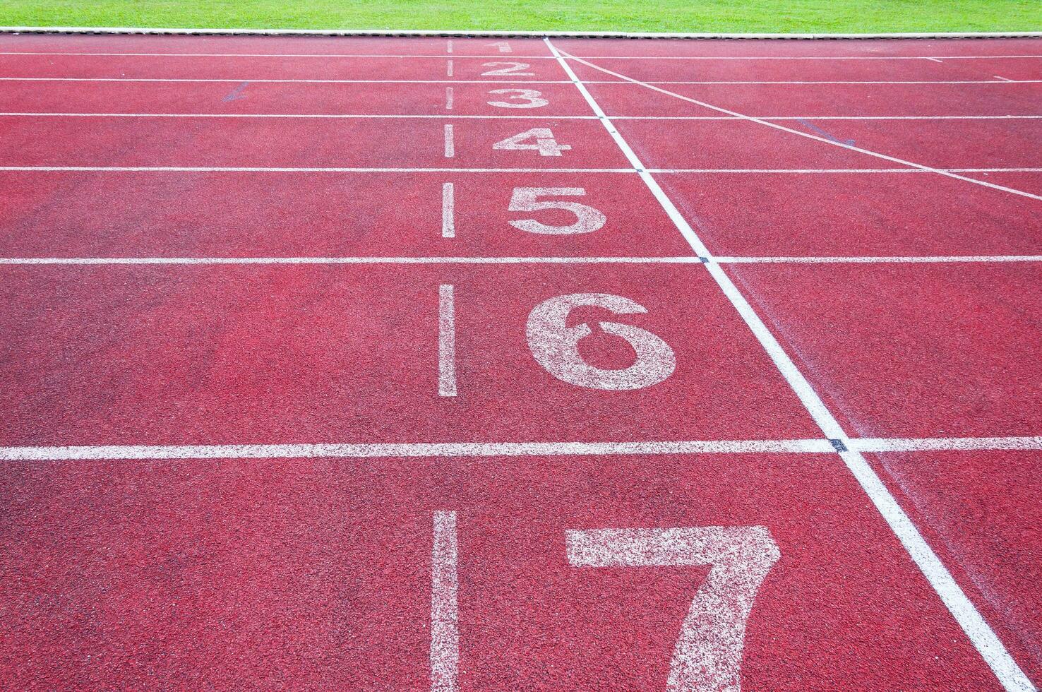 números comenzando punto en rojo corriendo pista, correr pista y verde hierba, directa atletismo corriendo pista a deporte estadio foto