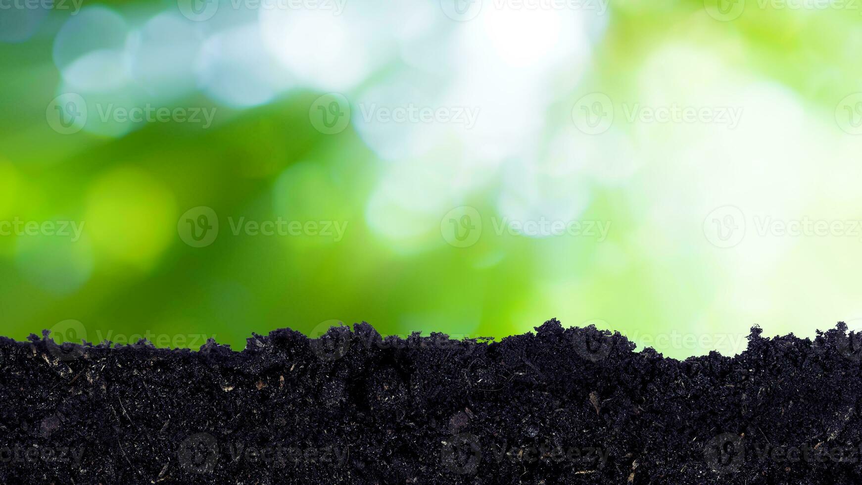 Heap of potting fertile black soil with green bokeh background, growing and organic plants ecology concept photo