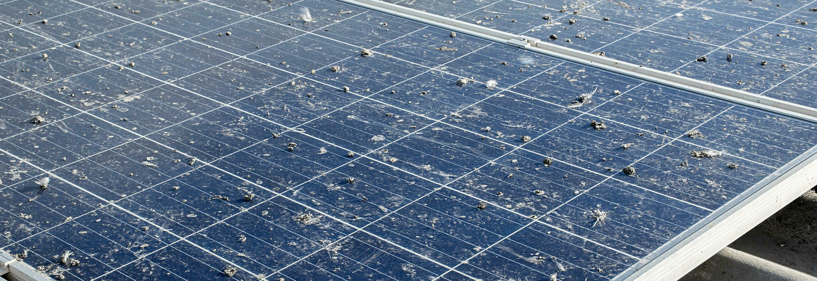 Upper surface of solar rooftop which has been used for a long time is stained with dust, bird droppings, dirt, smog and rainwater stains, concept for cleaning, washing and maintainance, cropped shot. photo