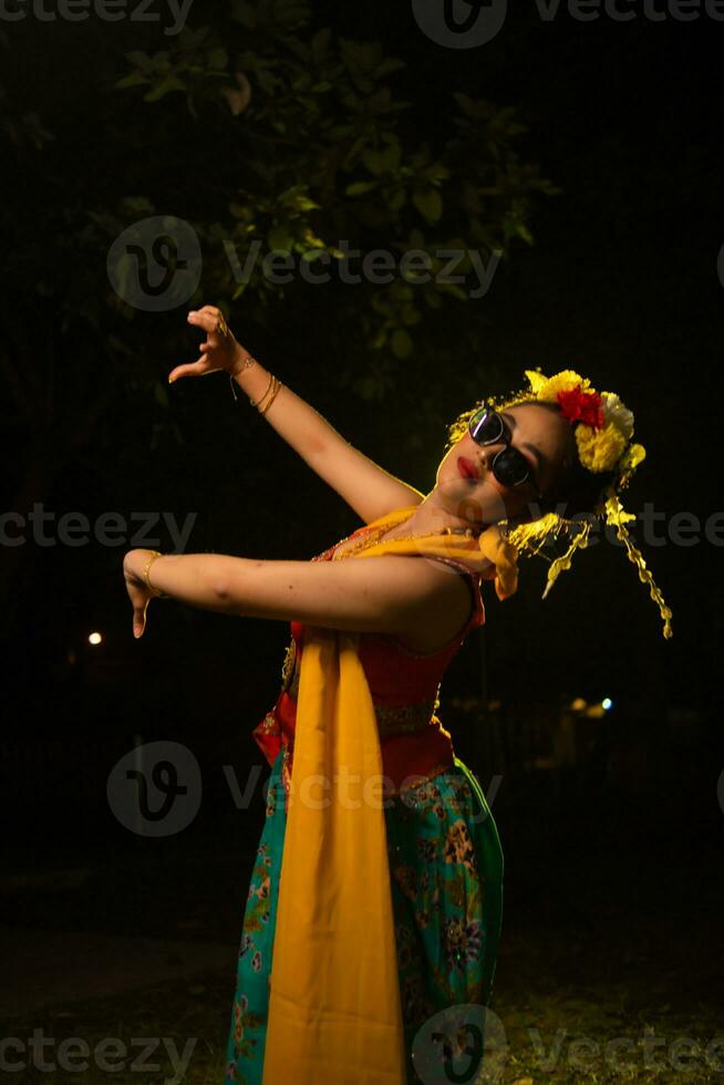 a traditional Indonesian dancer dancing with the body twisting on stage photo