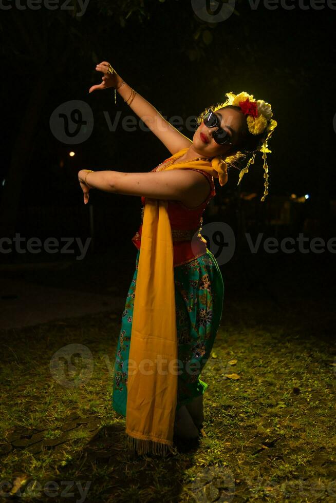un tradicional indonesio bailarín bailando con el cuerpo retortijón en etapa foto