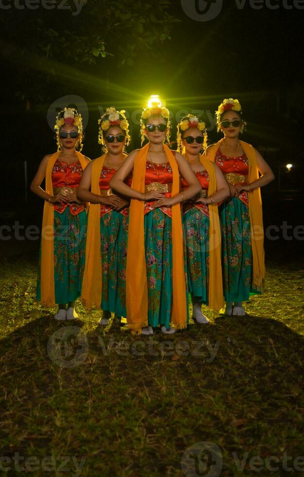 un grupo de indonesio tradicional bailarines danza con su amigos en frente de el etapa luces foto