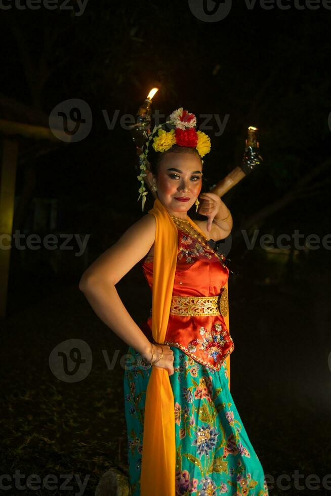 retrato de un javanés bailarín con flores en su cabeza y maquillaje en su hermosa cara foto