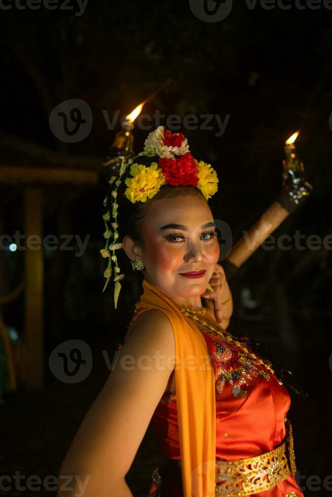 retrato de un javanés bailarín con flores en su cabeza y maquillaje en su hermosa cara foto