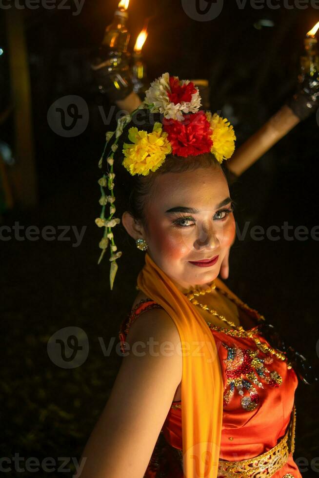 retrato de un javanés bailarín con flores en su cabeza y maquillaje en su hermosa cara foto
