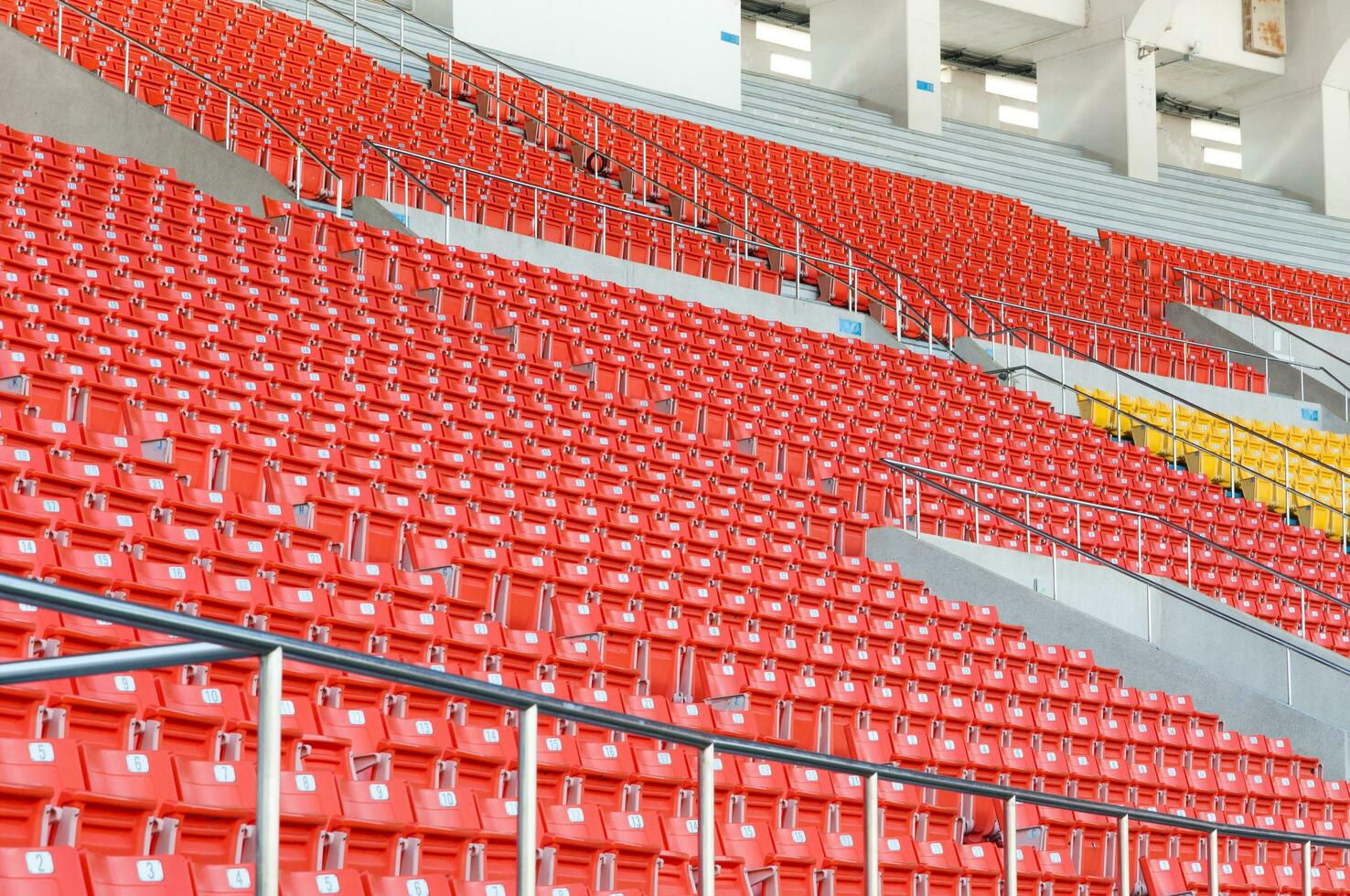 Empty orange seats at stadium,Rows walkway of seat on a soccer stadium photo