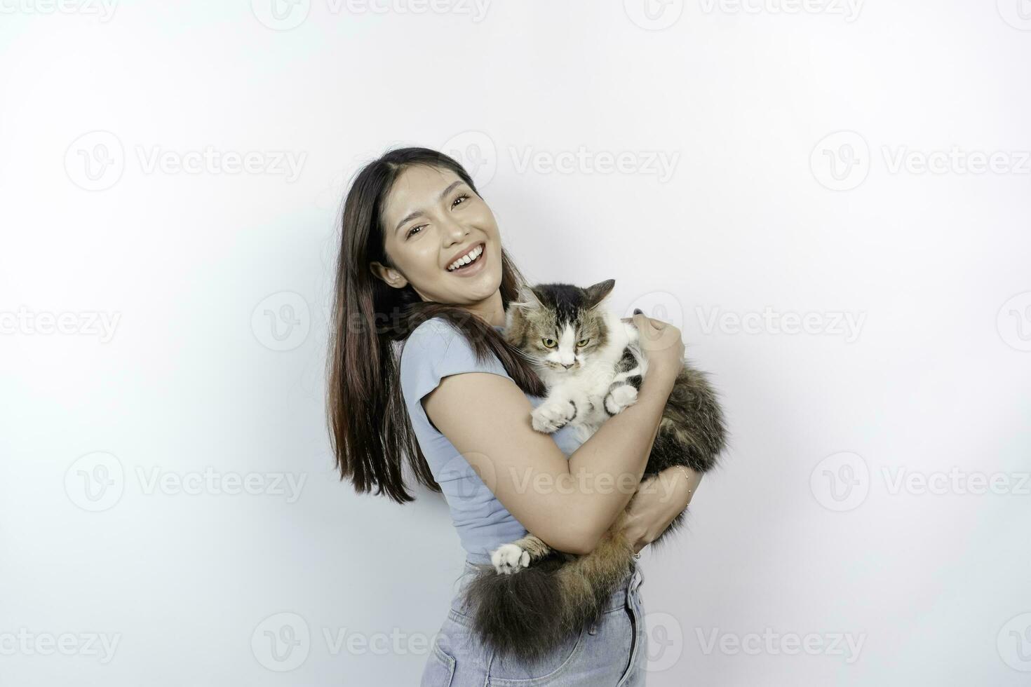 retrato de joven asiático mujer participación linda angora gato con amarillo ojos. hembra abrazando su linda largo pelo gatito aislado por blanco antecedentes. adorable Doméstico mascota concepto. foto