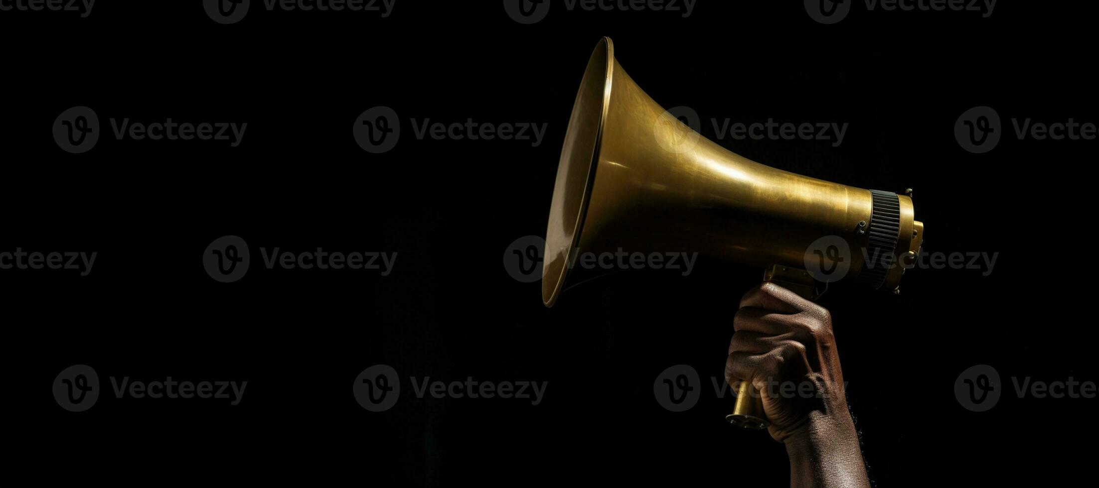 Generative AI, golden megaphone in hand on a empty black background, panoramic image with copy space photo