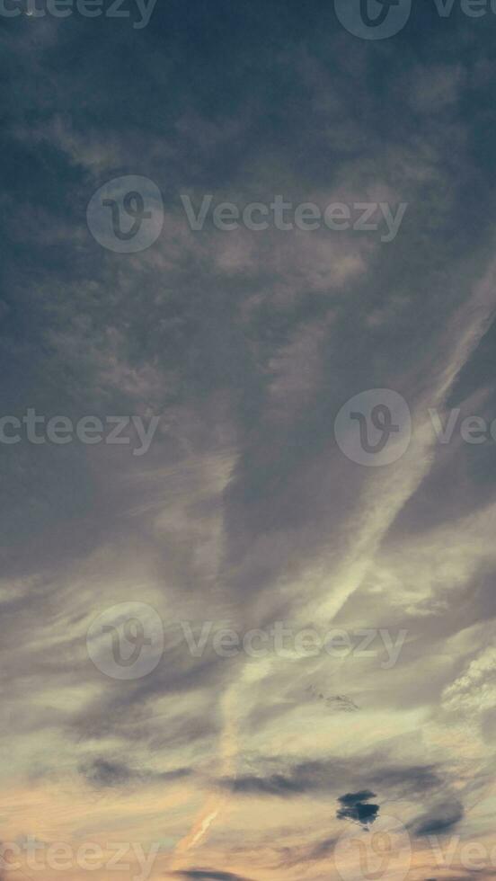 oscuridad vertical,puesta de sol cielo crepúsculo en el noche con vistoso luz de sol y oscuro azul cielo con nubes, majestuoso verano bonito cielo vertical. foto