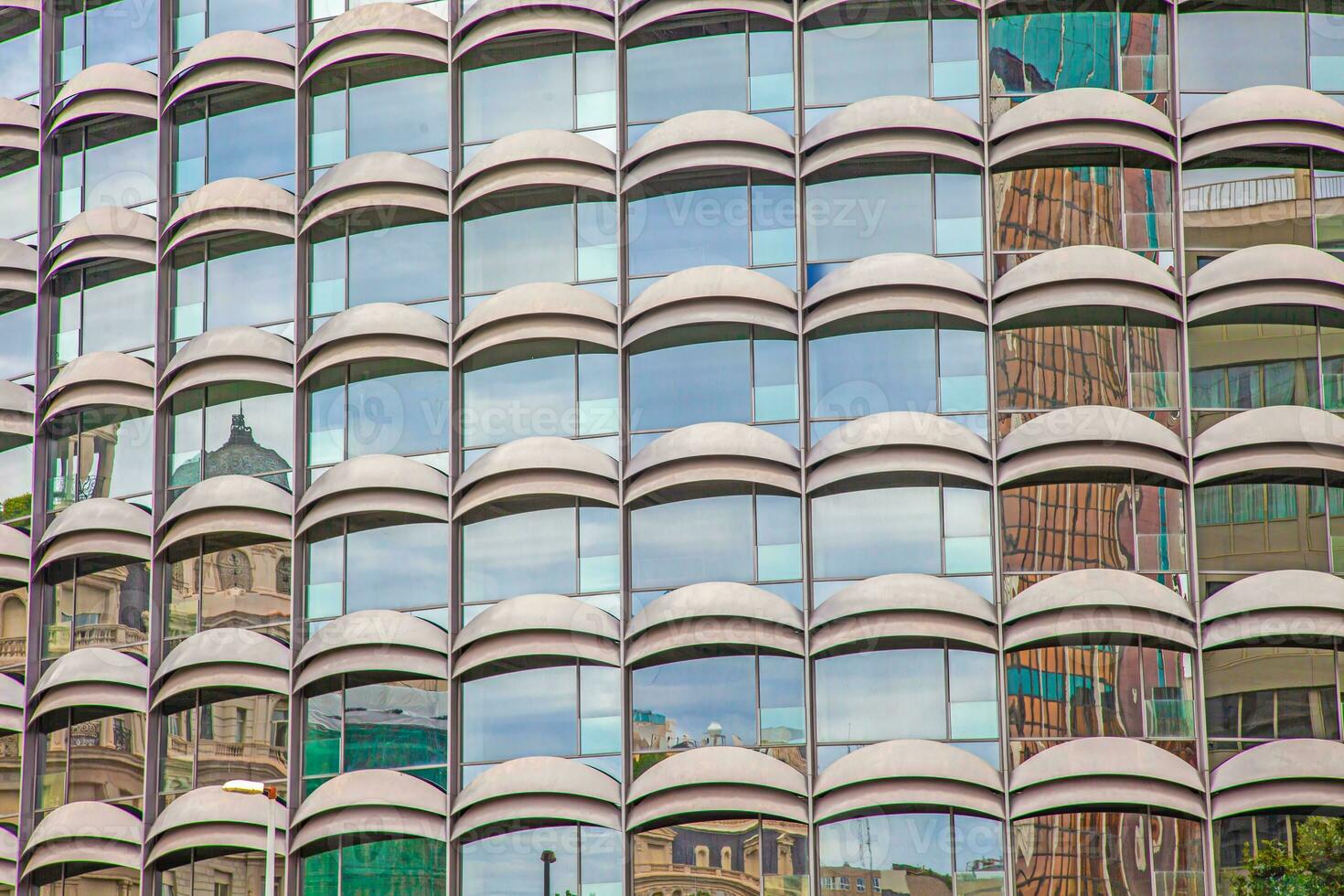 Image of a symetric facade of a high-rise building with scuppers in the glass facade photo