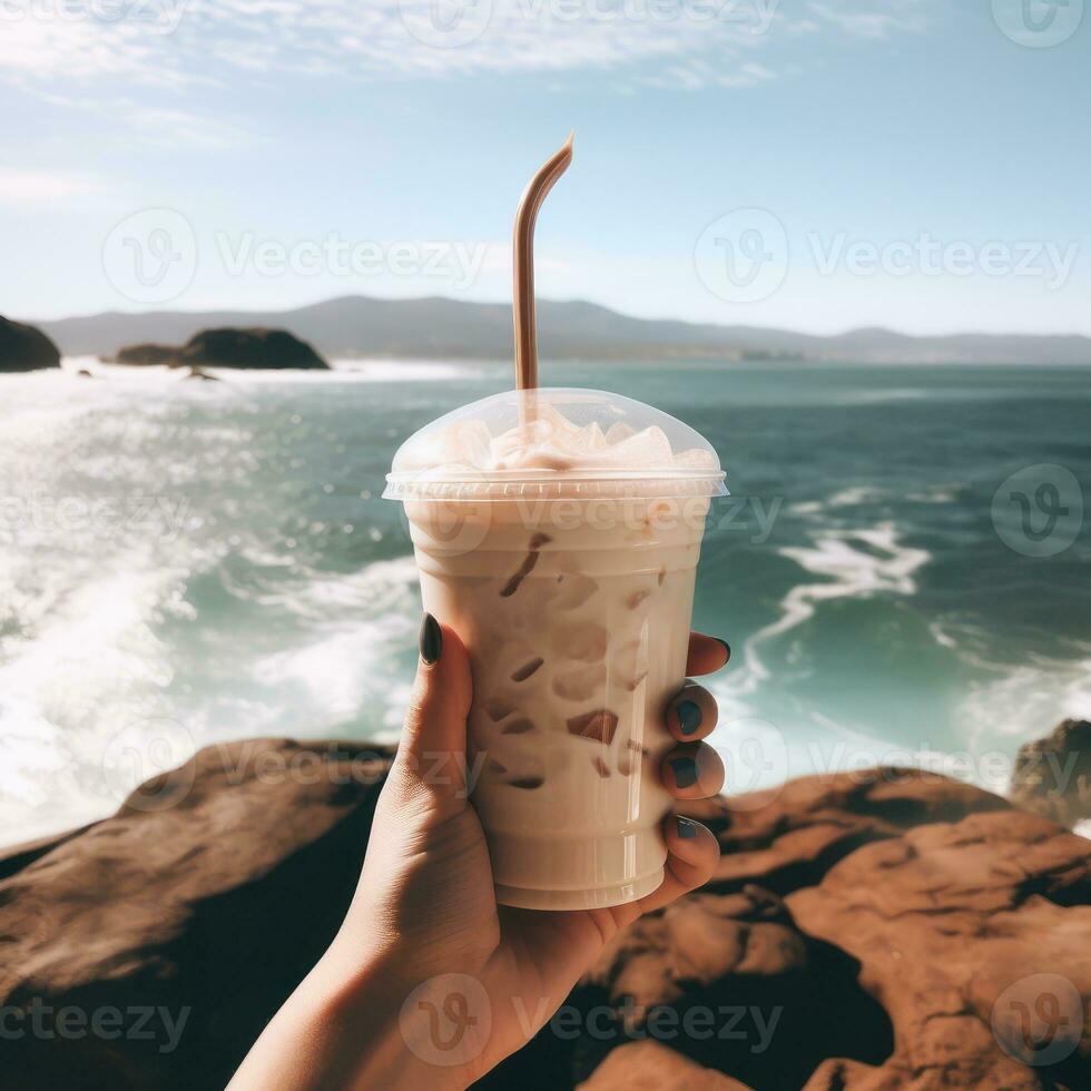 Young woman holding iced coffee at the beach with blue clear water. Generative Ai. photo