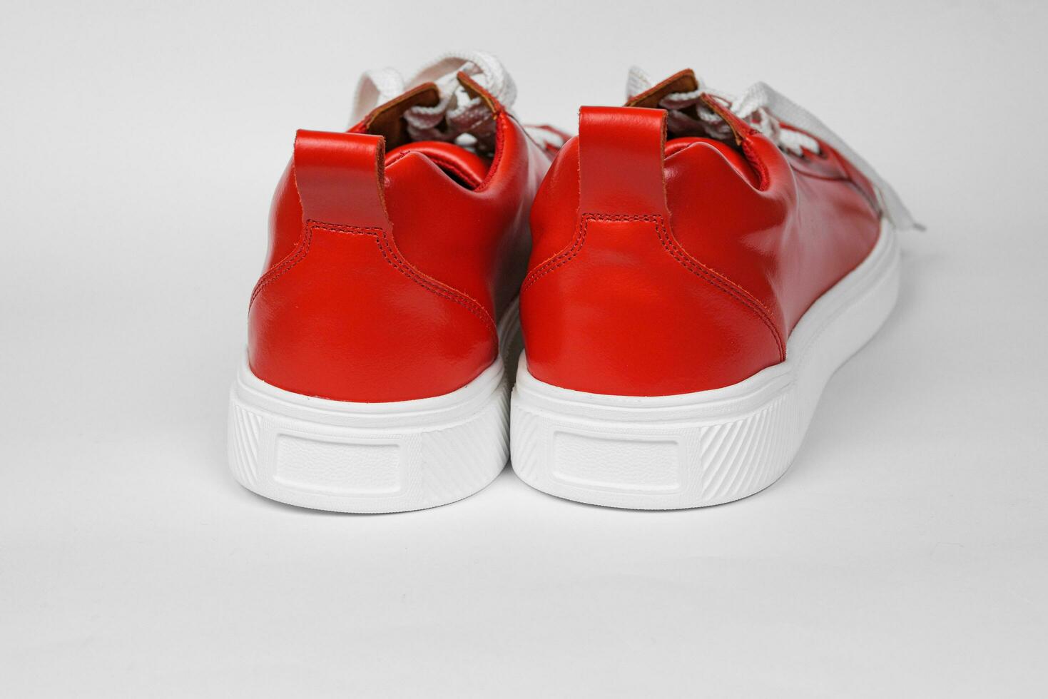 Red leather sneakers with white soles photo