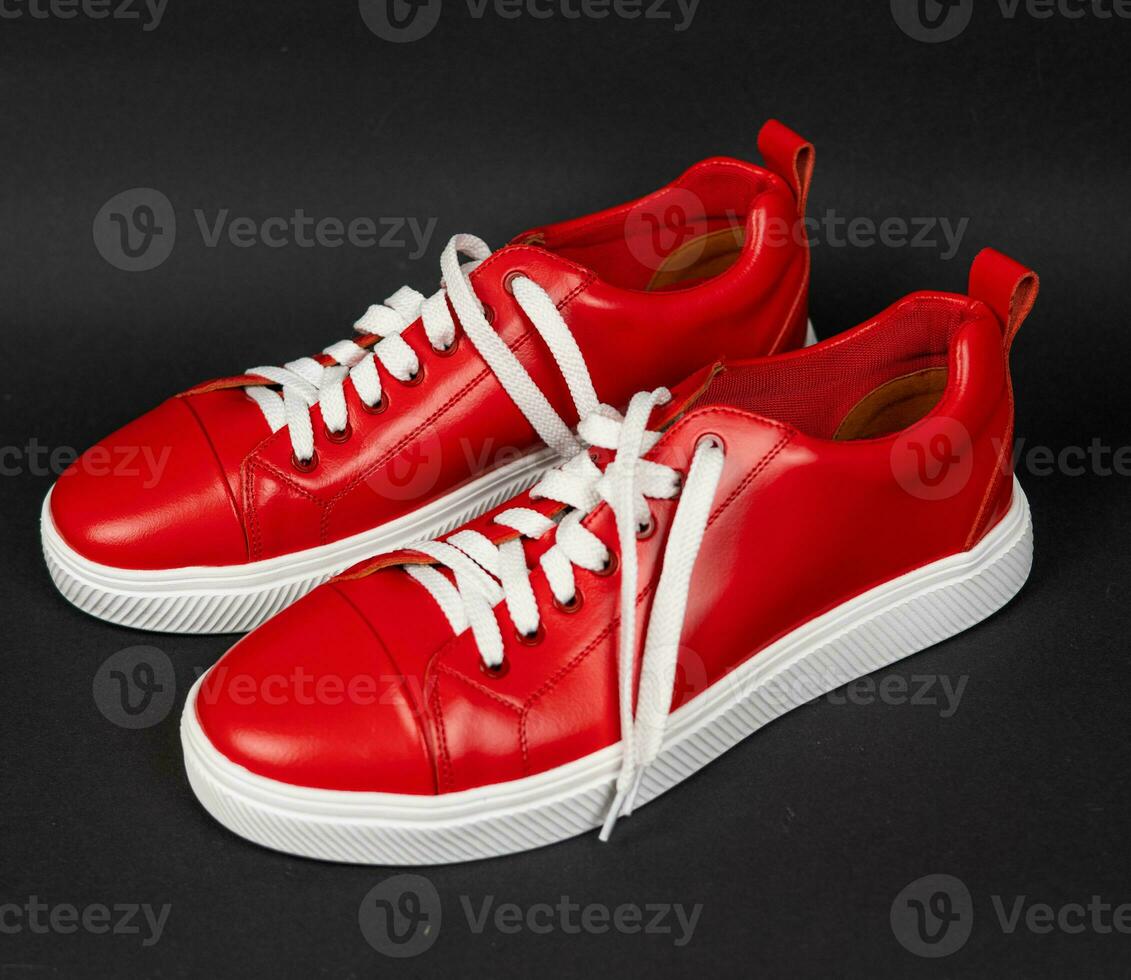 New Red leather sneakers with white soles on a black background photo