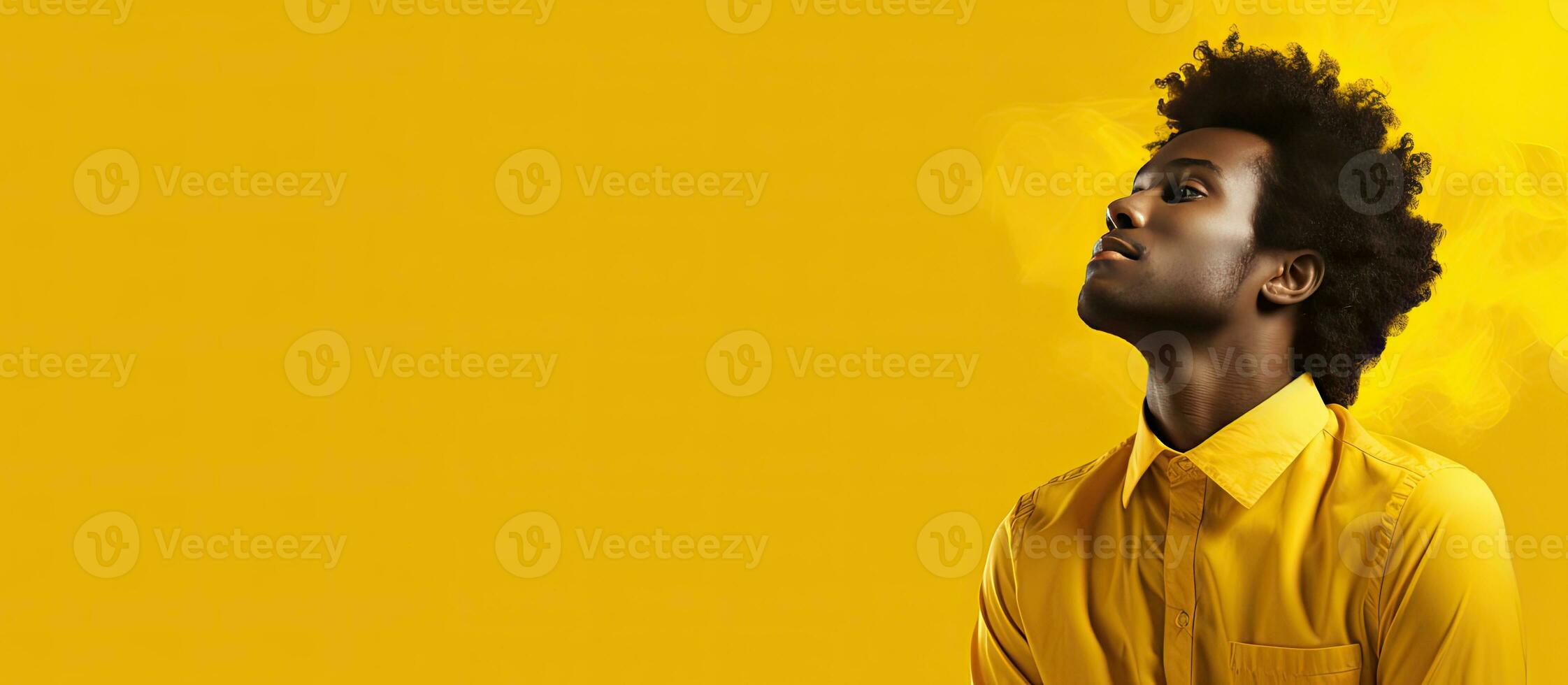 African man contemplating on yellow background with room for writing photo