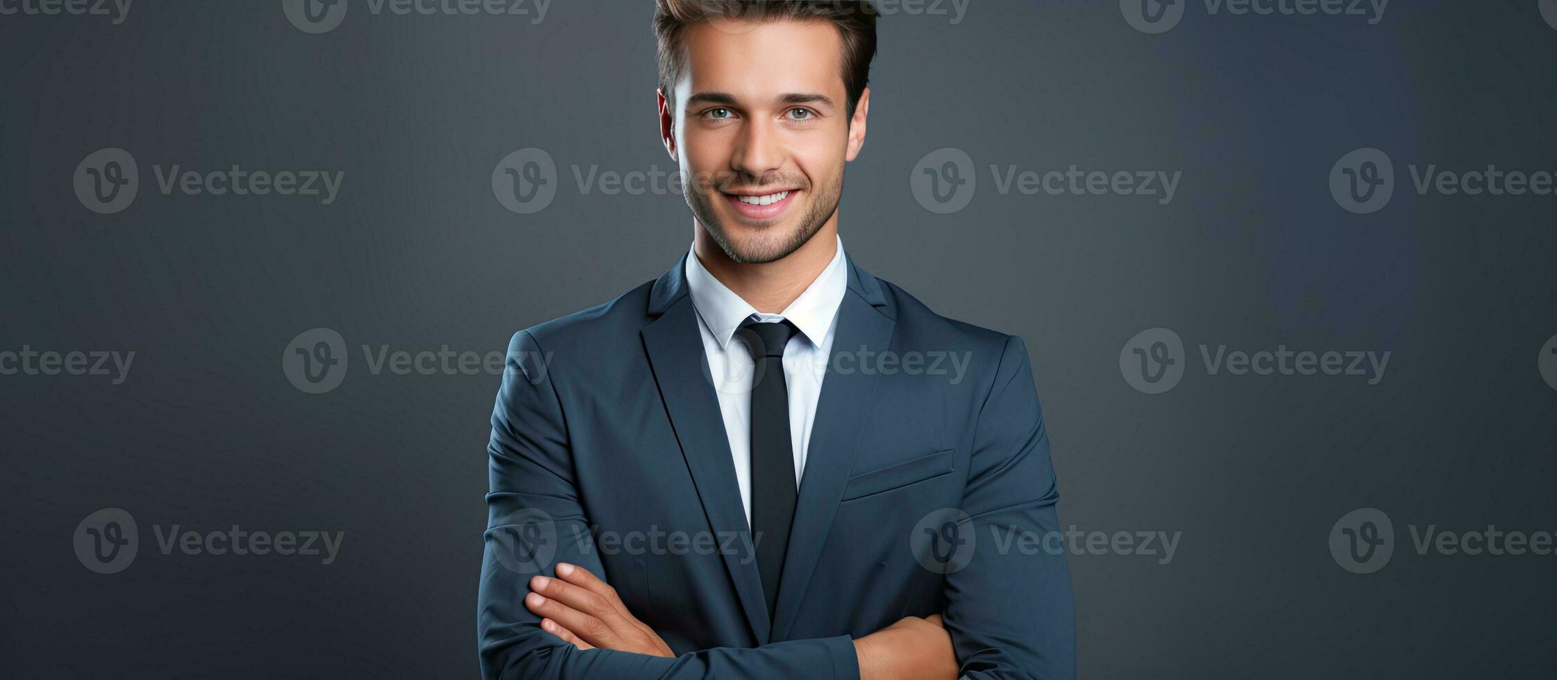 A young smiling businessman with a laptop isolated on a gray background photo