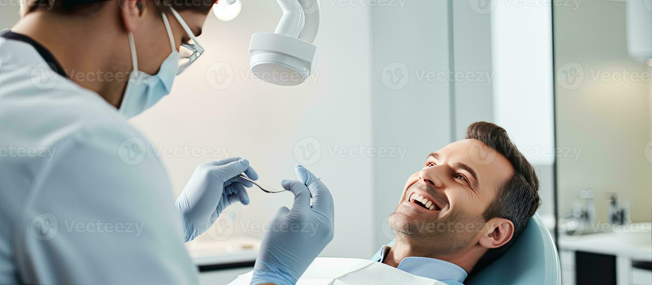 Young male dentist examining mature male patient in dental clinic with dental tools Wide image with copy space on right side photo