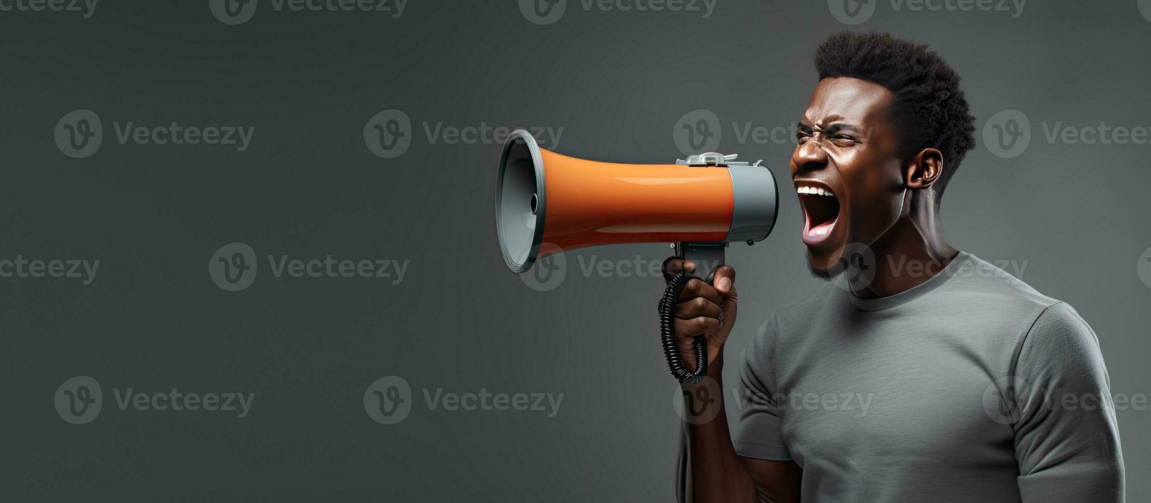 Energetic black man with megaphone excitedly advertising over gray background photo