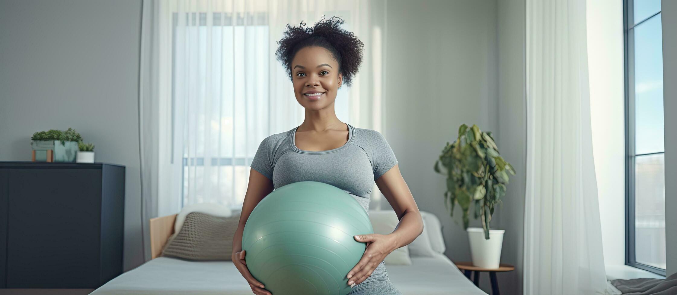 Pregnant black woman exercising with weights and yoga ball looking at camera indoors photo