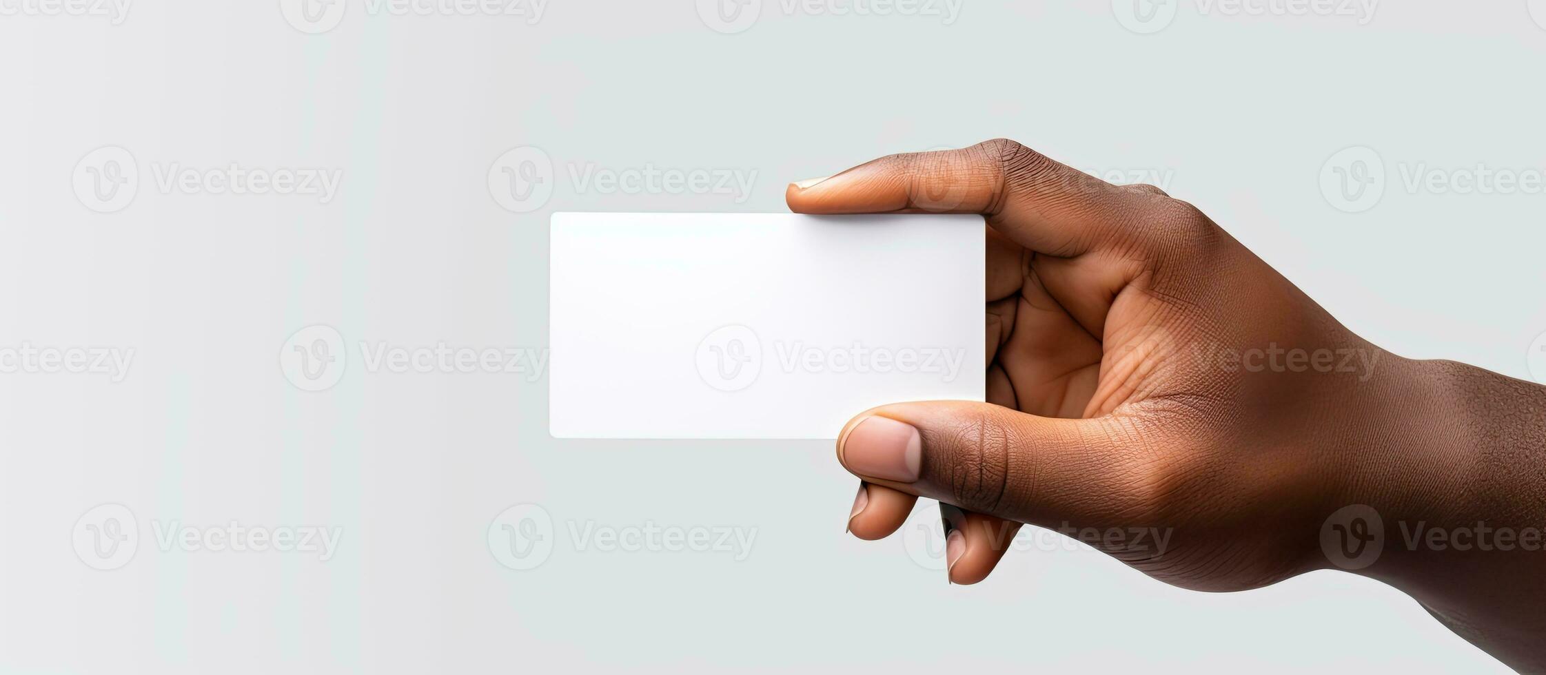Hand of biracial man holding a black business card with empty area on white background representing the idea of business stationery and writing space photo