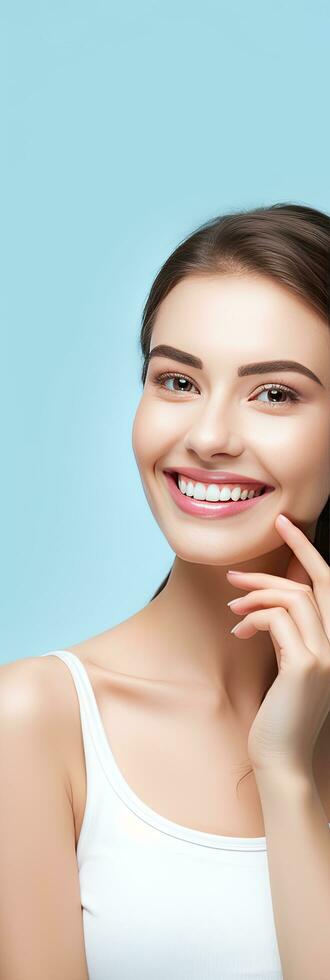 Woman demonstrates healthy and perfect teeth on blue background promoting dental treatment and oral care photo