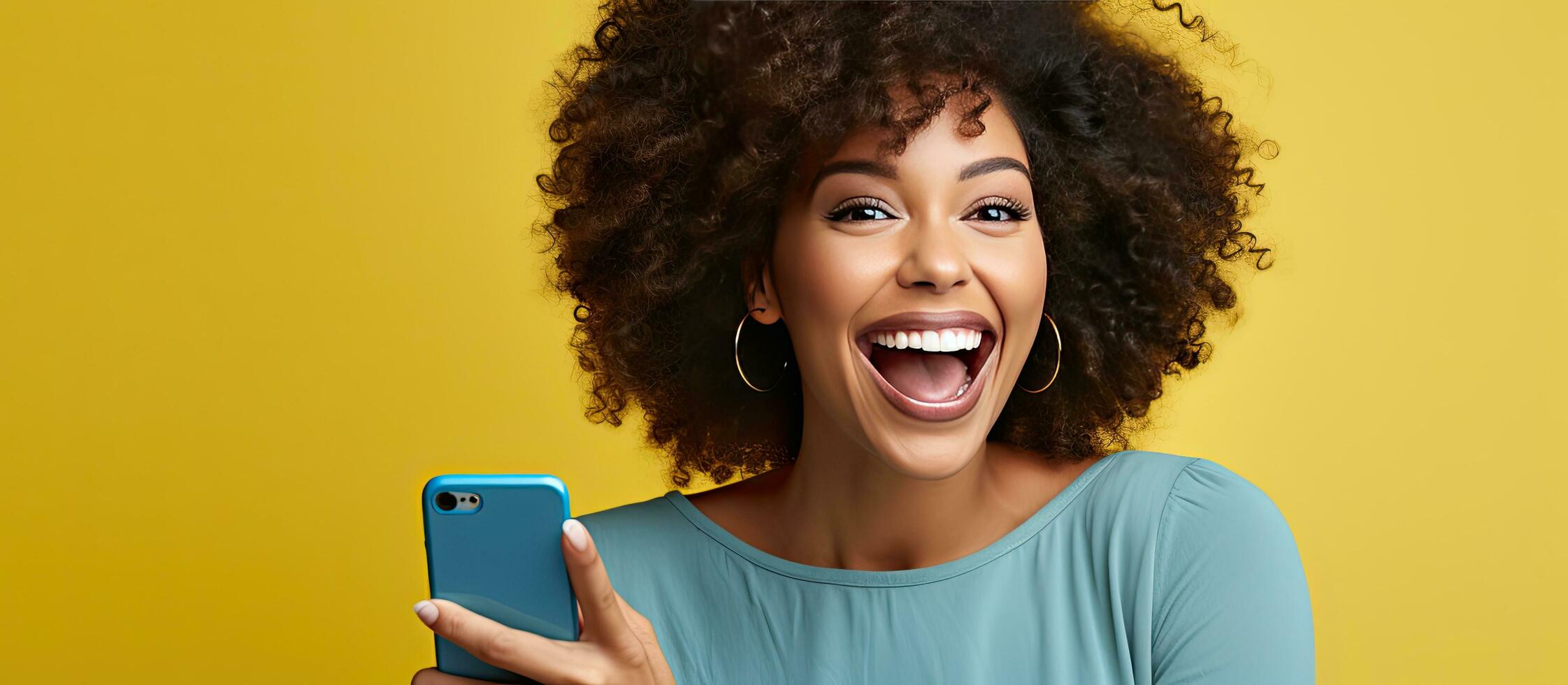 Smiling woman with afro hair uses phone for work and social media dressed in blue with yellow background photo