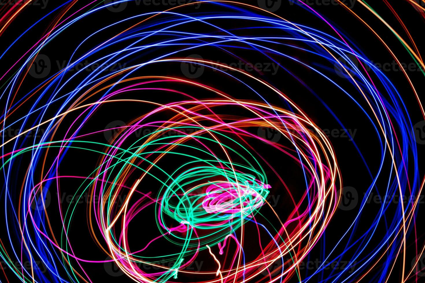 Multi color light painting photography, swirl and curve of blue, green and red light against a black background. photo