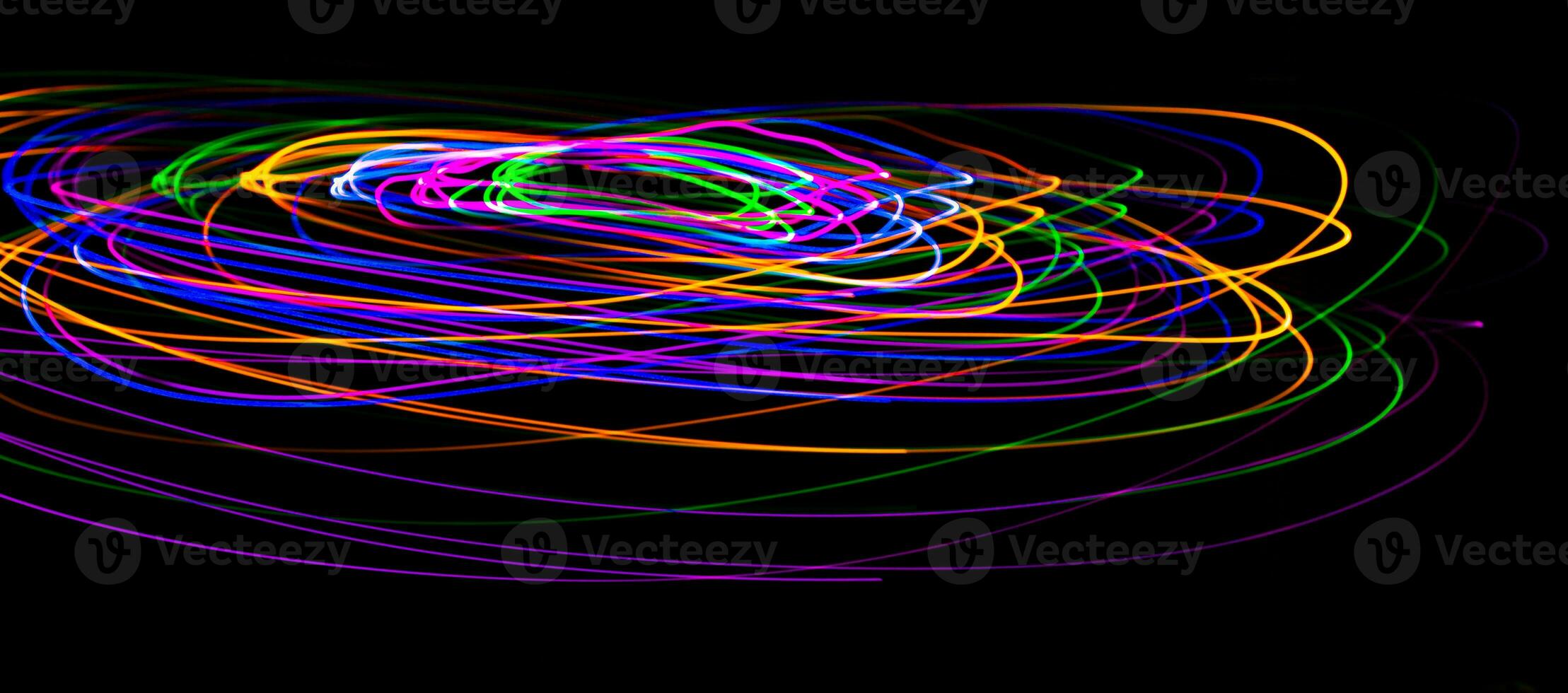 Multi color light painting photography, swirl and curve of blue, green and red light against a black background. photo