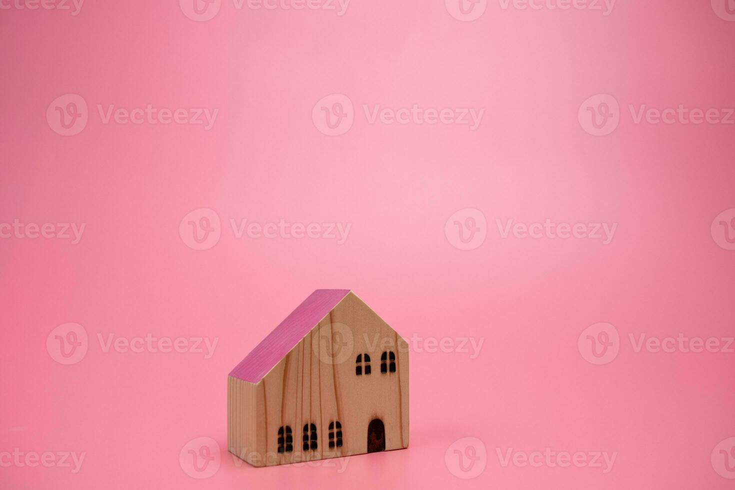 Wood house model on pink background , managing property investment concept, banner background photo