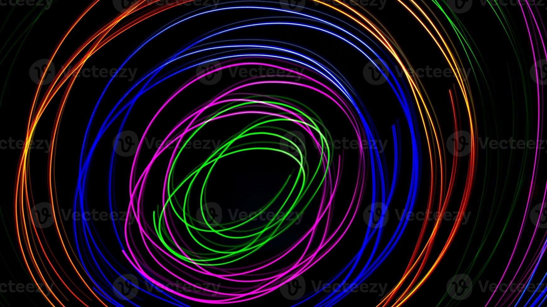 Multi color light painting photography, swirl and curve of blue, green and red light against a black background. photo