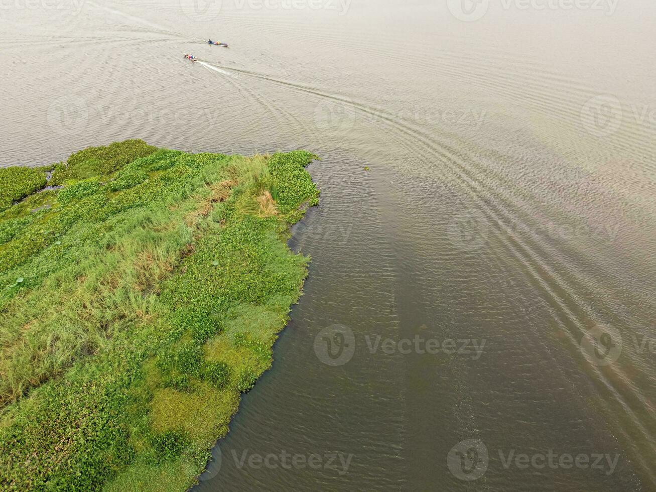 un pescar barco estaba navegación en un grande laguna. foto