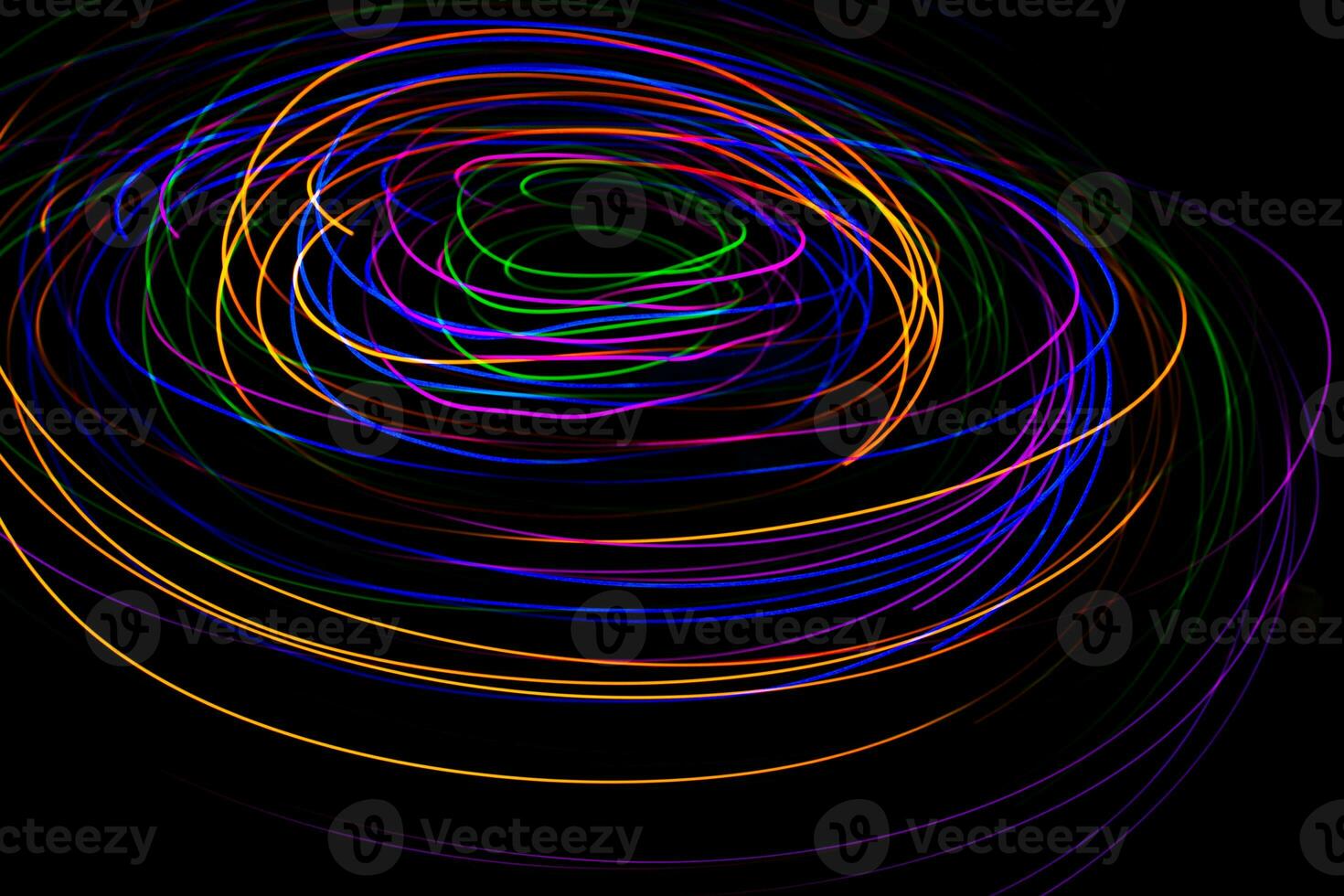 Multi color light painting photography, swirl and curve of blue, green and red light against a black background. photo