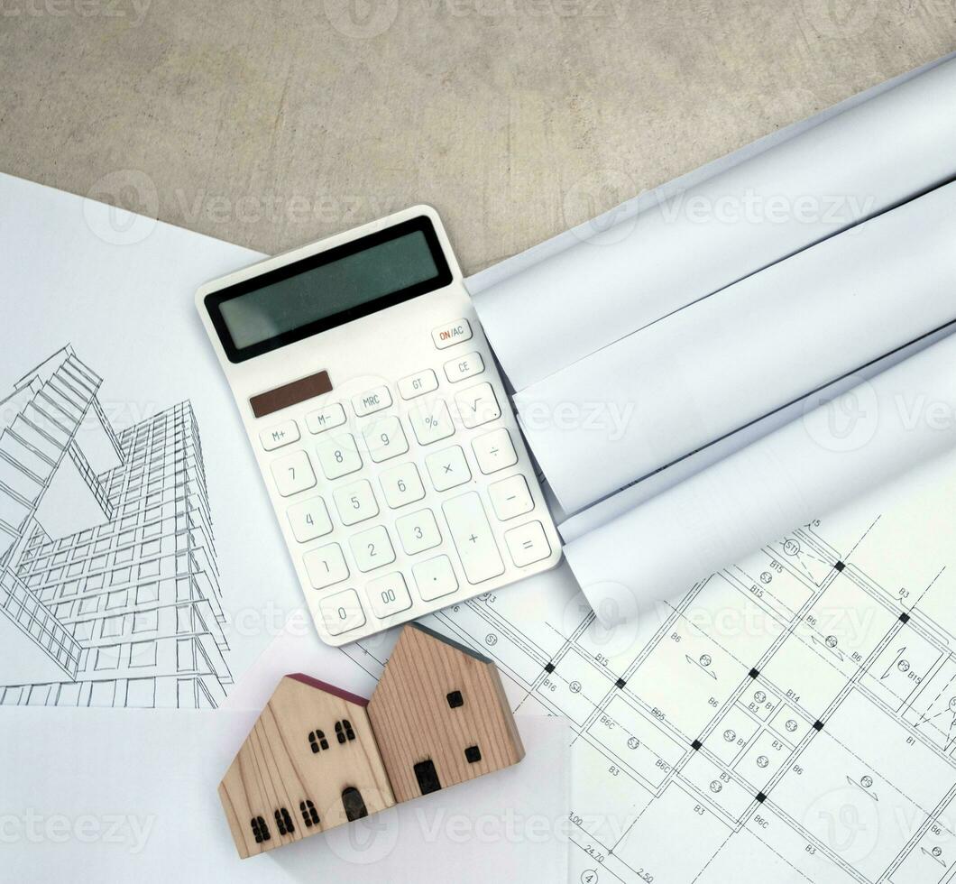 real estate and property, architecture, building, construction concept - Tiny house model on an architect's desk photo