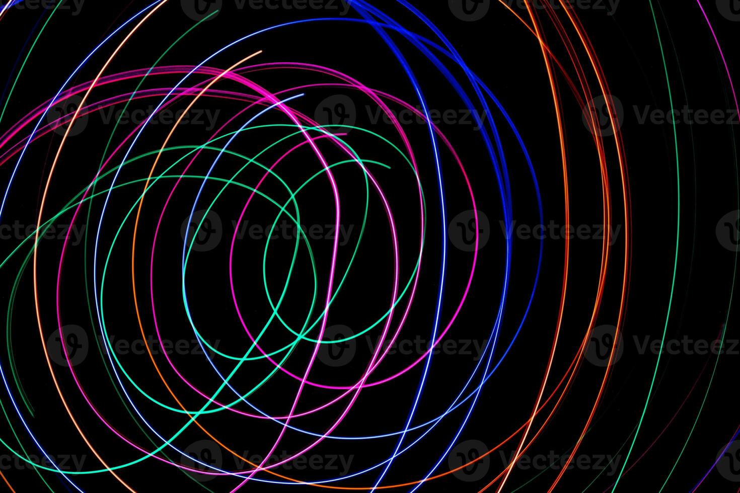 Multi color light painting photography, swirl and curve of blue, green and red light against a black background. photo