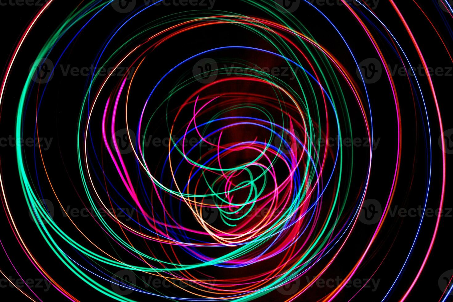 Multi color light painting photography, swirl and curve of blue, green and red light against a black background. photo