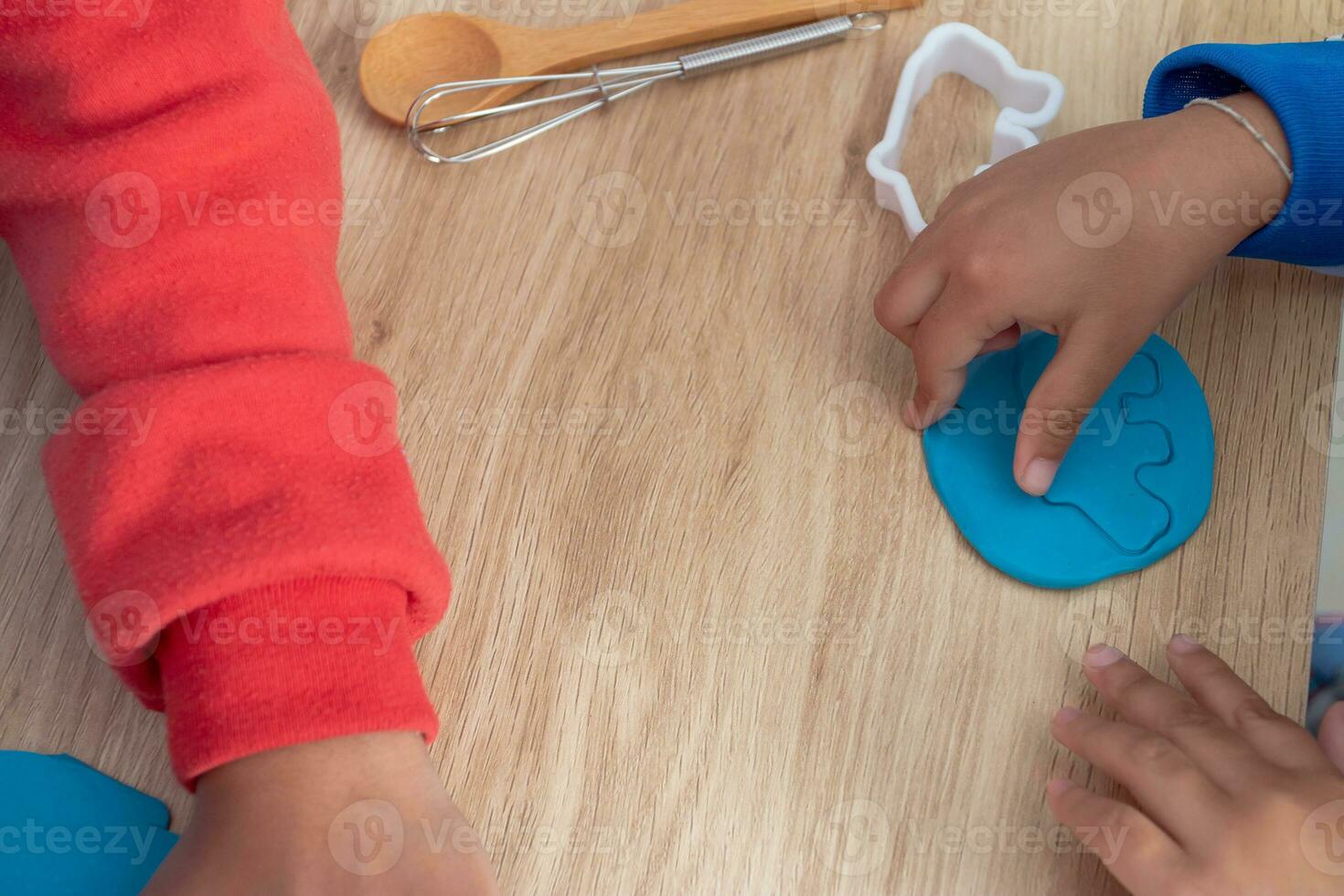 Children's hands and simulation cooking toys in the kitchen counter. photo