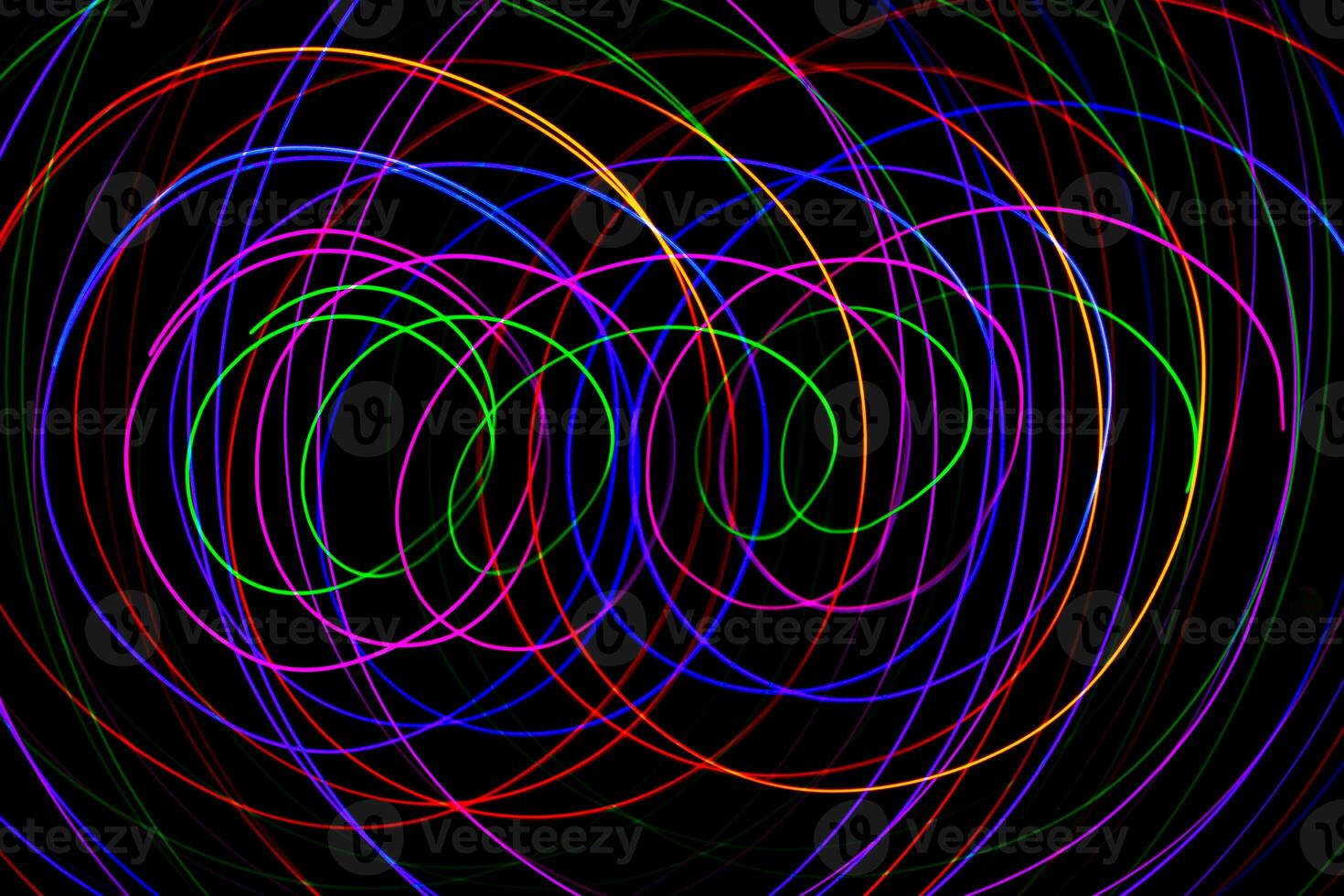 Multi color light painting photography, swirl and curve of blue, green and red light against a black background. photo