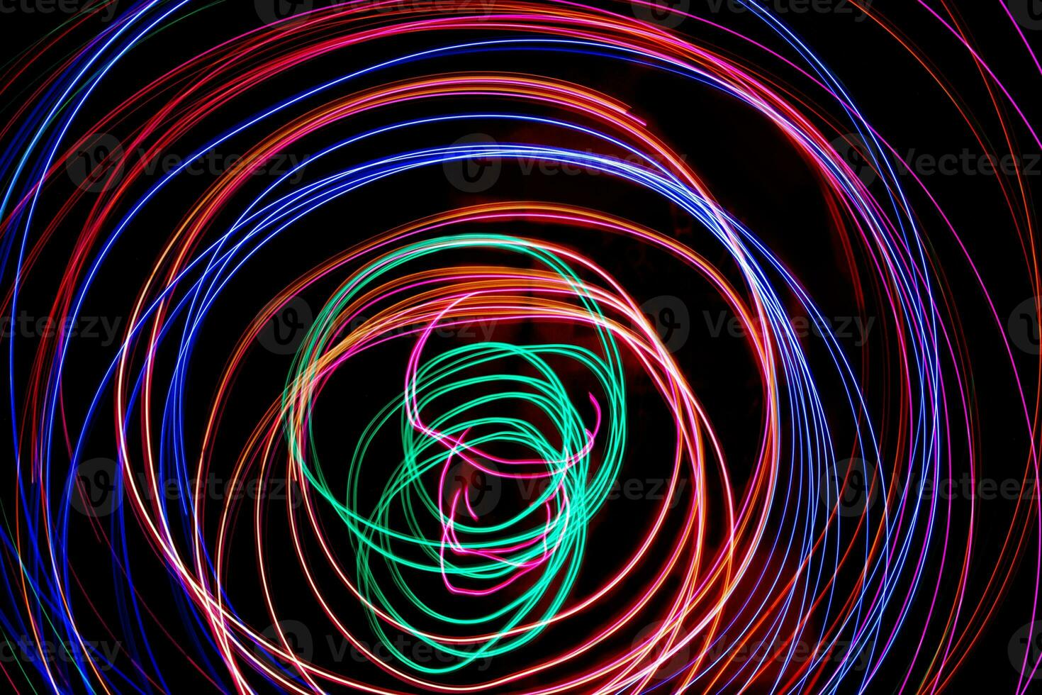 Multi color light painting photography, swirl and curve of blue, green and red light against a black background. photo