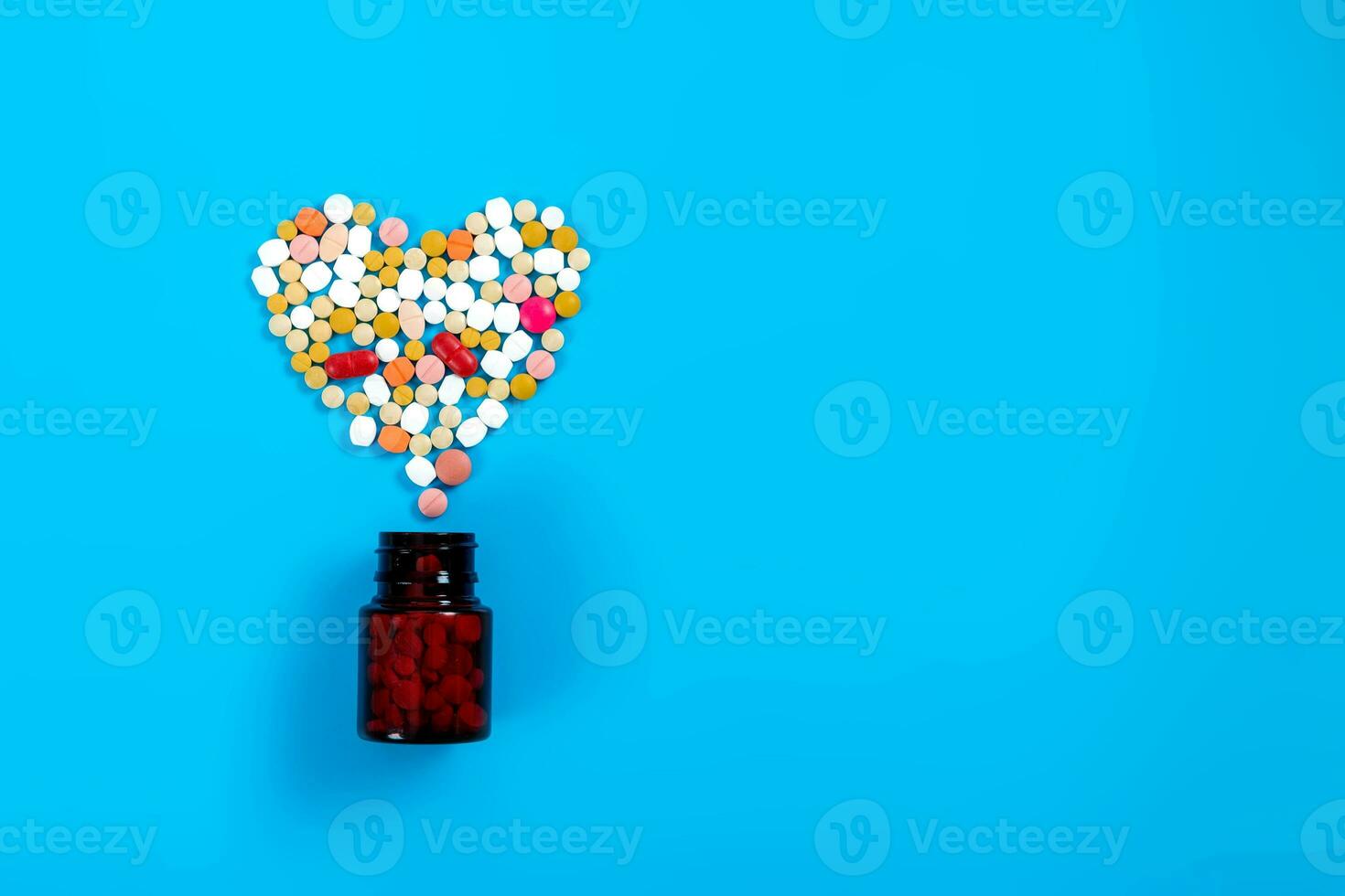 Assorted pharmaceutical medicine pills, tablets for the treatment of heart disease. Heart shape and bottle of pills. Copy space for text photo