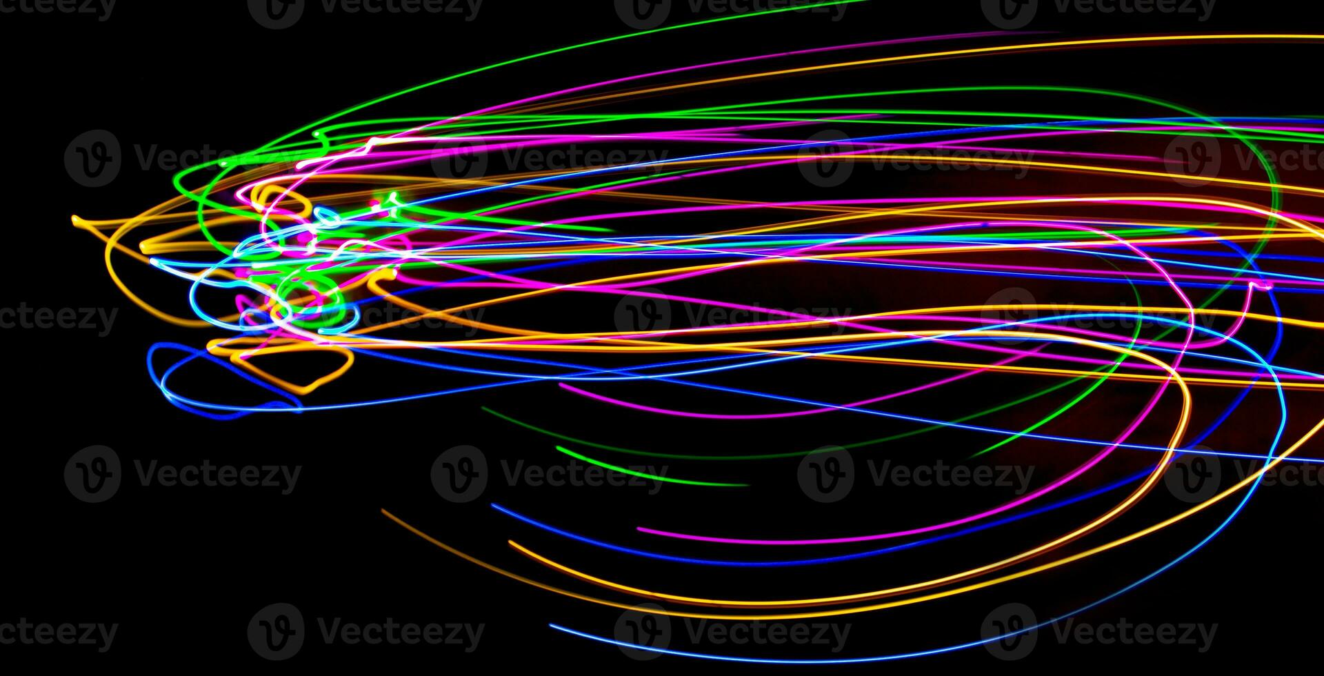 Multi color light painting photography, swirl and curve of blue, green and red light against a black background. photo