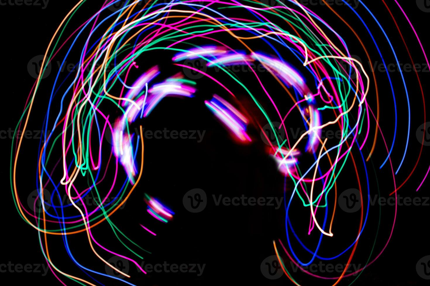 Multi color light painting photography, swirl and curve of blue, green and red light against a black background. photo