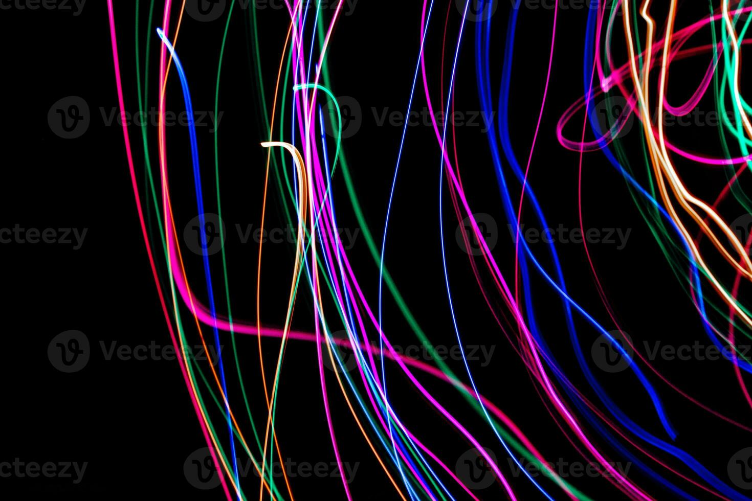 Multi color light painting photography, swirl and curve of blue, green and red light against a black background. photo