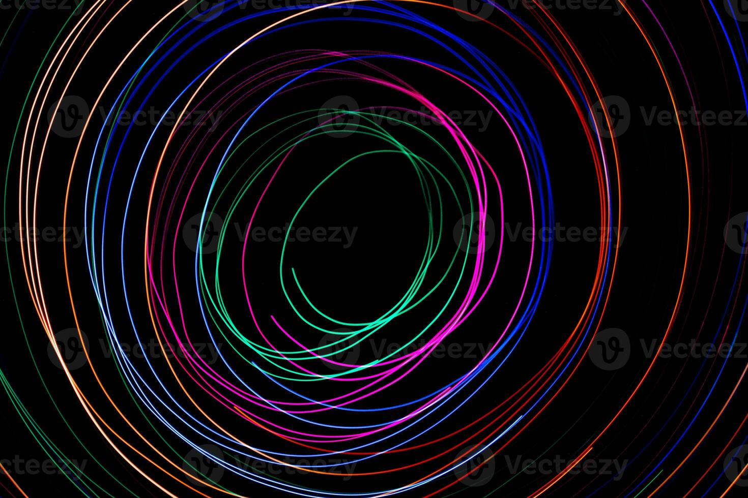 Multi color light painting photography, swirl and curve of blue, green and red light against a black background. photo
