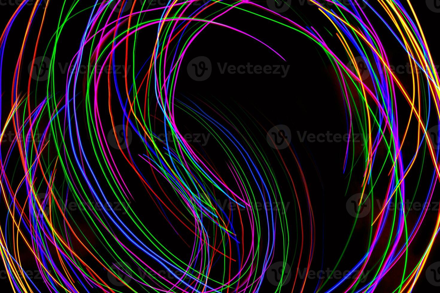 Multi color light painting photography, swirl and curve of blue, green and red light against a black background. photo