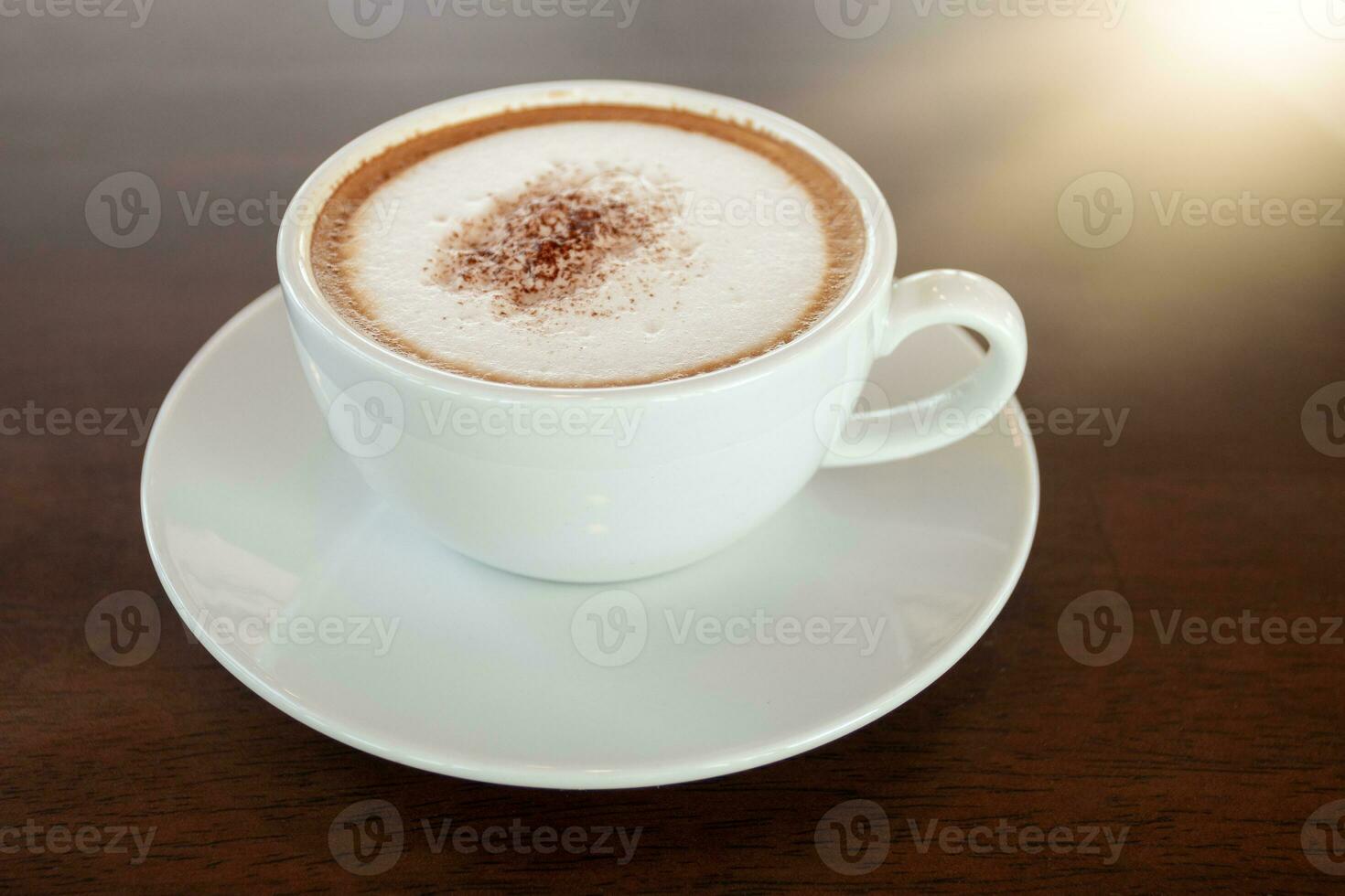 Coffee cup of cappuccino on wooden table in cafe photo