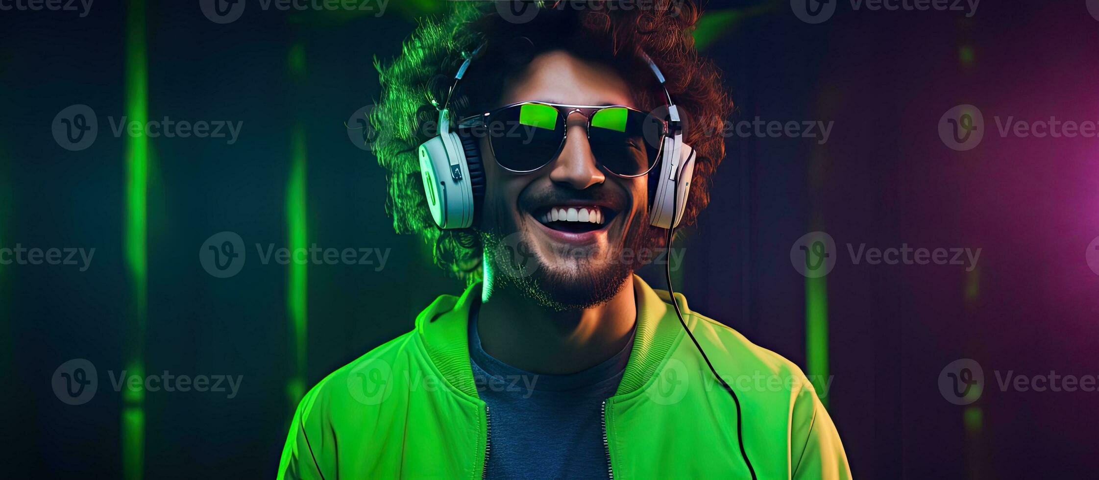 Man with headphones enjoying music and dancing DJ with joyful smile hipster teen lifestyle portrait with green background and neon lights open area for te photo